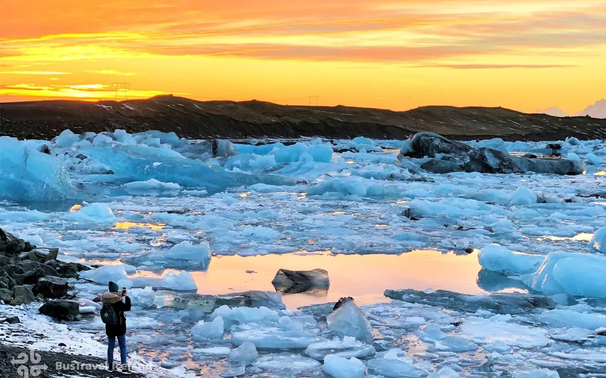 Clear blocks of ice stranded on a beach of black sand