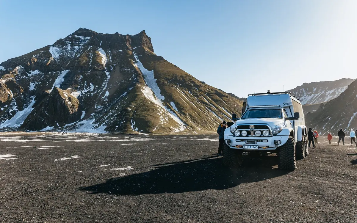 A super jeep on the black sand plain below the glacier above Vík