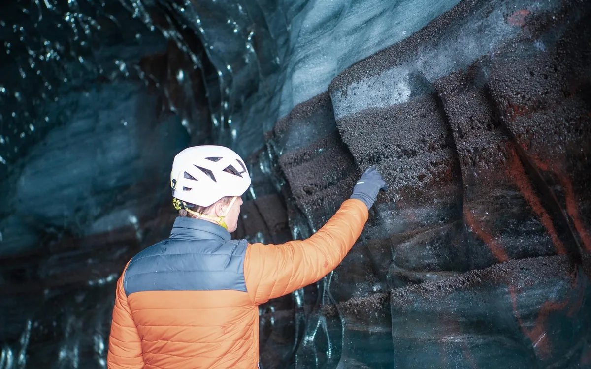 Walkers in crampons and helmets on the ice margin of Mýrdalsjökull above Vík